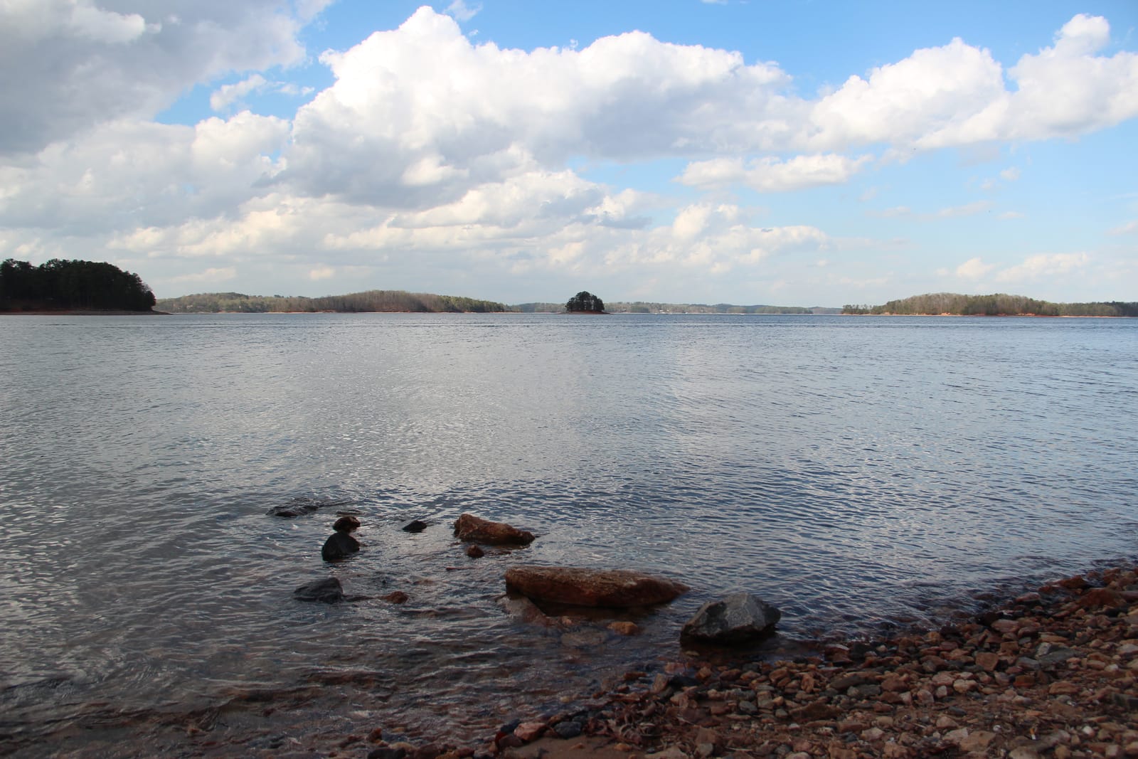 Rocky shoreline on Lake Lanier in early spring, with small islands on the horizon
